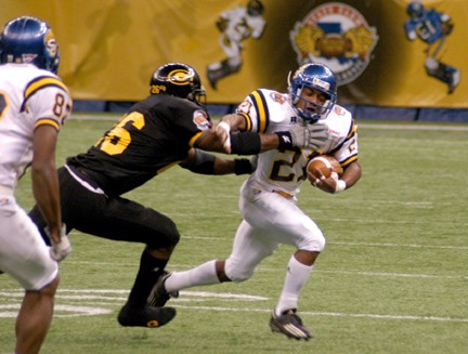 Birmingham Senior running back Gerald Holmes stiff-arms a GSU defender on a 12 yard run. - Photo by Ryan Knight/DIGEST