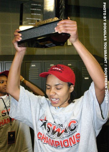 Senior guard Shere' Cunningham holds up the SWAC Tournament Trophy in the celebrating locker room of the Southern University Jaguars after defeating Mississippi Valley to earn the SWAC's automatic bid to the NCAA Tournament. This will be SU's second appea