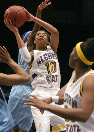 Alcorn State's LaToya Johnson alters her shot in mid-air avoiding a block attempt by Southern's Rolanda Monroe. Johnson, along with Monroe, was named to the All-SWAC tournament team and finished with five points. PHOTO BY JOSH HALLEY