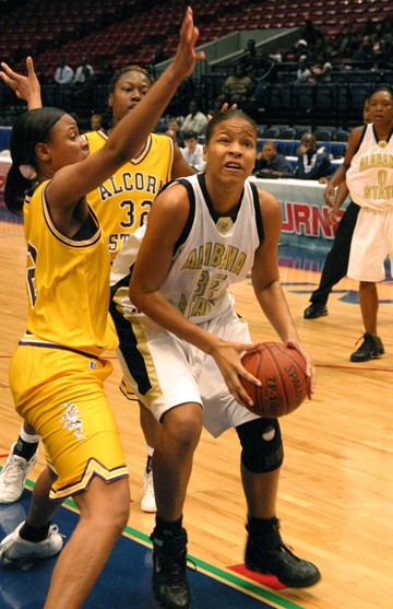 Alabama State freshman, Dominique Rowe, drives to the basket past Alcorn State defenders during the women's quarterfinal. (PHOTO BY DOUGLAS W. TOUSSAINT, JR.)