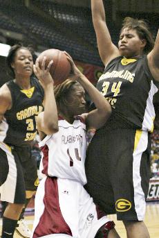 Lady Bulldog Felicia Drummond is swarmed by the Lady Tigers' Dominique Headd and Lacey Cormier afer driving into the lane. Cormier, the SWAC's Defensive Player of the Year, blocked five shots during the game.
