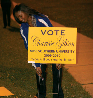 Miss Southern candidate Charisse Gibson places a yard sign to promote her candidacy for Miss Southern.