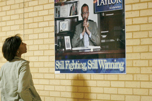 Former SGA Vice President Stasha Rhodes gazes at an election poster for current SGA president Jamal Taylor, which features her photo.