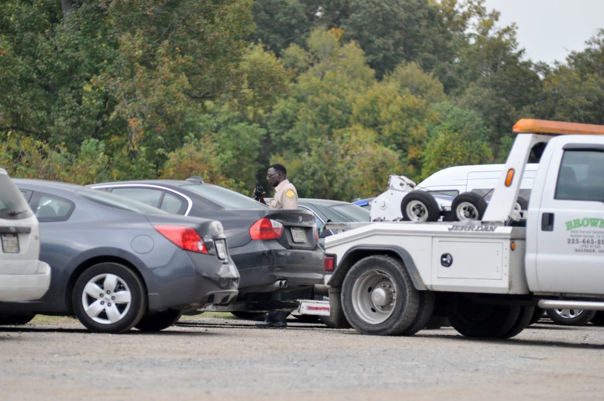 A Southern University traffic police officer calls in to confirm a spontaneous towing of a student's car in the parking lot across from T. T. Allain Hall yesterday.