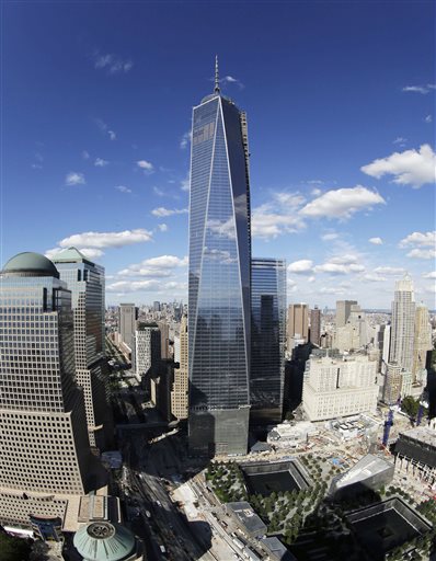 FILE - In this Thursday, Sept. 5, 2013, file photo taken with a fisheye lens, One World Trade Center, center, overlooks the wedge-shaped pavilion entrance of the National September 11 Museum, lower right, and the square outlines of the memorial waterfalls in New York. The long-awaited museum dedicated to the victims of the Sept. 11 terror attacks will open to the public at the World Trade Center site on May 21, officials announced Monday, March 24, 2014. (AP Photo/Mark Lennihan, File)