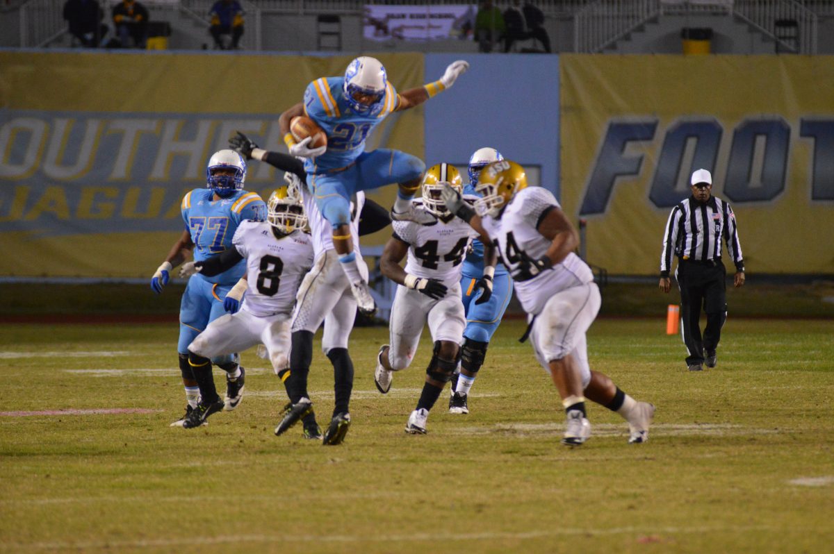 Showing a test of true leg strength while trying to escape the ASU defense, redshirt sophomore running back, Lenard Tillery, hurdles in the air on the night that Southern captured their fourth consecutive SWAC conference win against Alabama State.