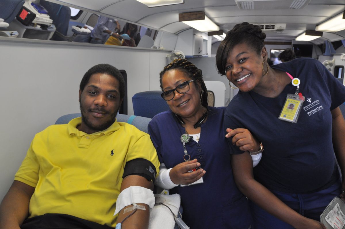 Gerian Lane, Sophmore Music Major from New Orleans, relaxes as senior technician and donor technician Margaret Andrews and Kimberly Wesley pose with him