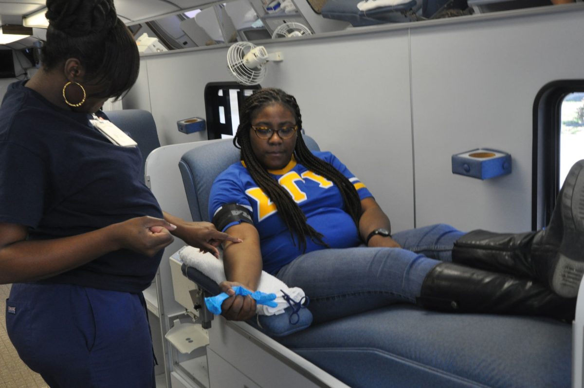 Donor technician Kimberly Wesley tends to Eglle Rich, junior social work major from Kenner, as she prepares to donate blood.