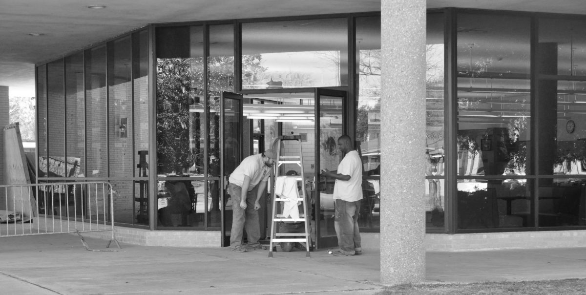 Construction workers repairing the front door of John B. Cade Library.