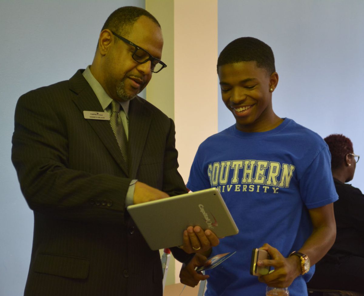 A Capital One representative speaks with a student about alternative banking options during welcome week block party hosted by the Southern University Office of Student Life.