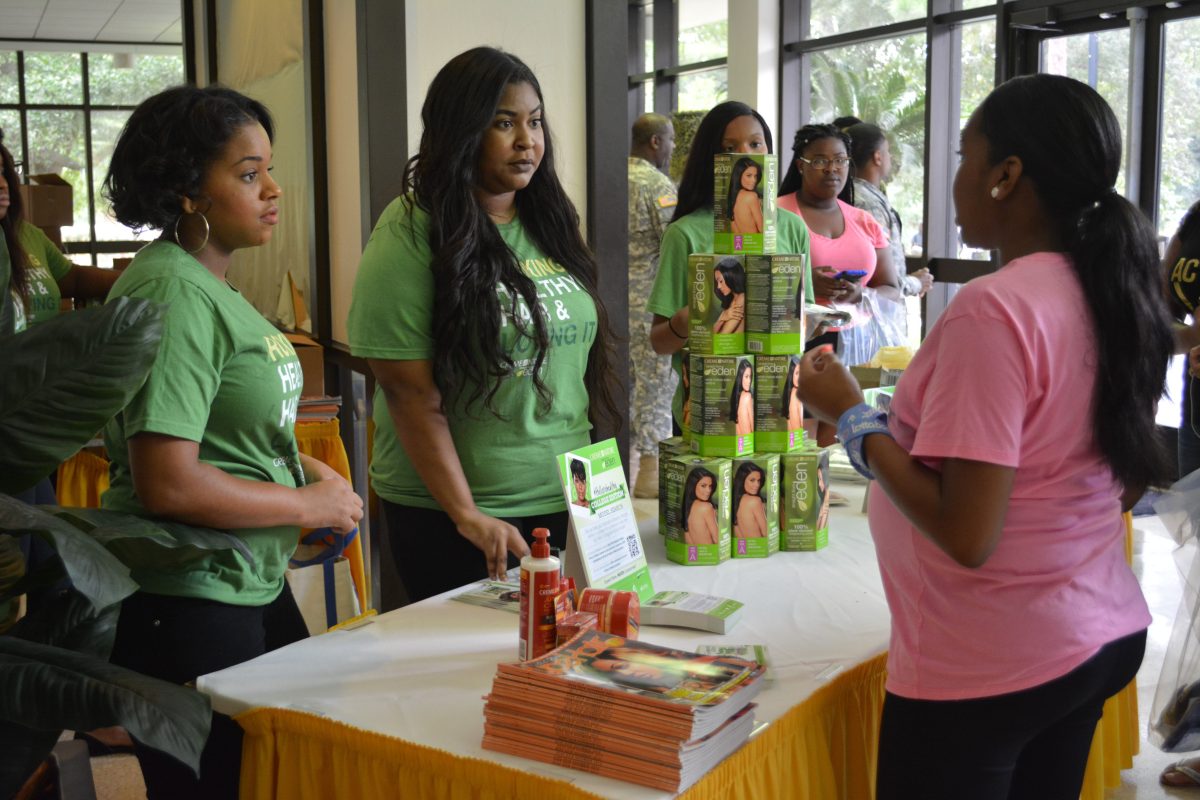 Creme of Nature Student Ambassadors give students complimentary hair care products during the Welcome Week Block Party.