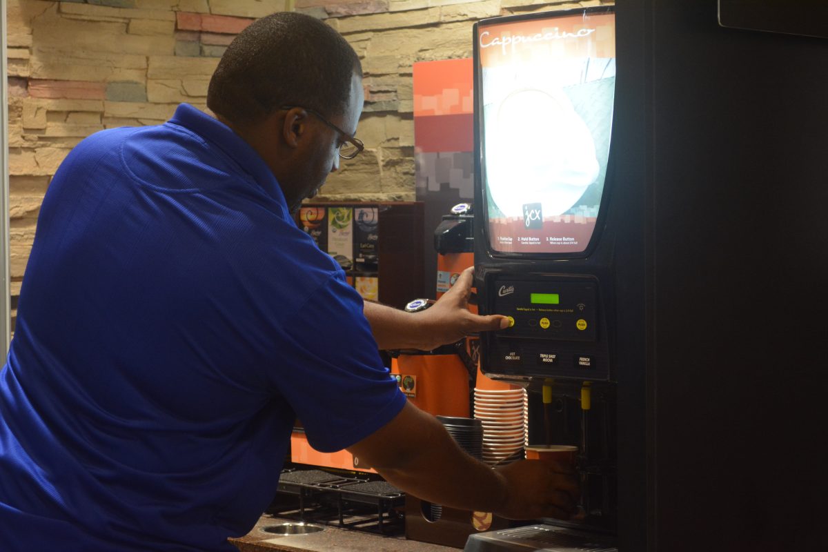 Anthony Jackson, Assistant Vice Chancellor for Student Affairs, samples complimentary coffee from newly renovated Smith-Brown Memorial Union restaurants.