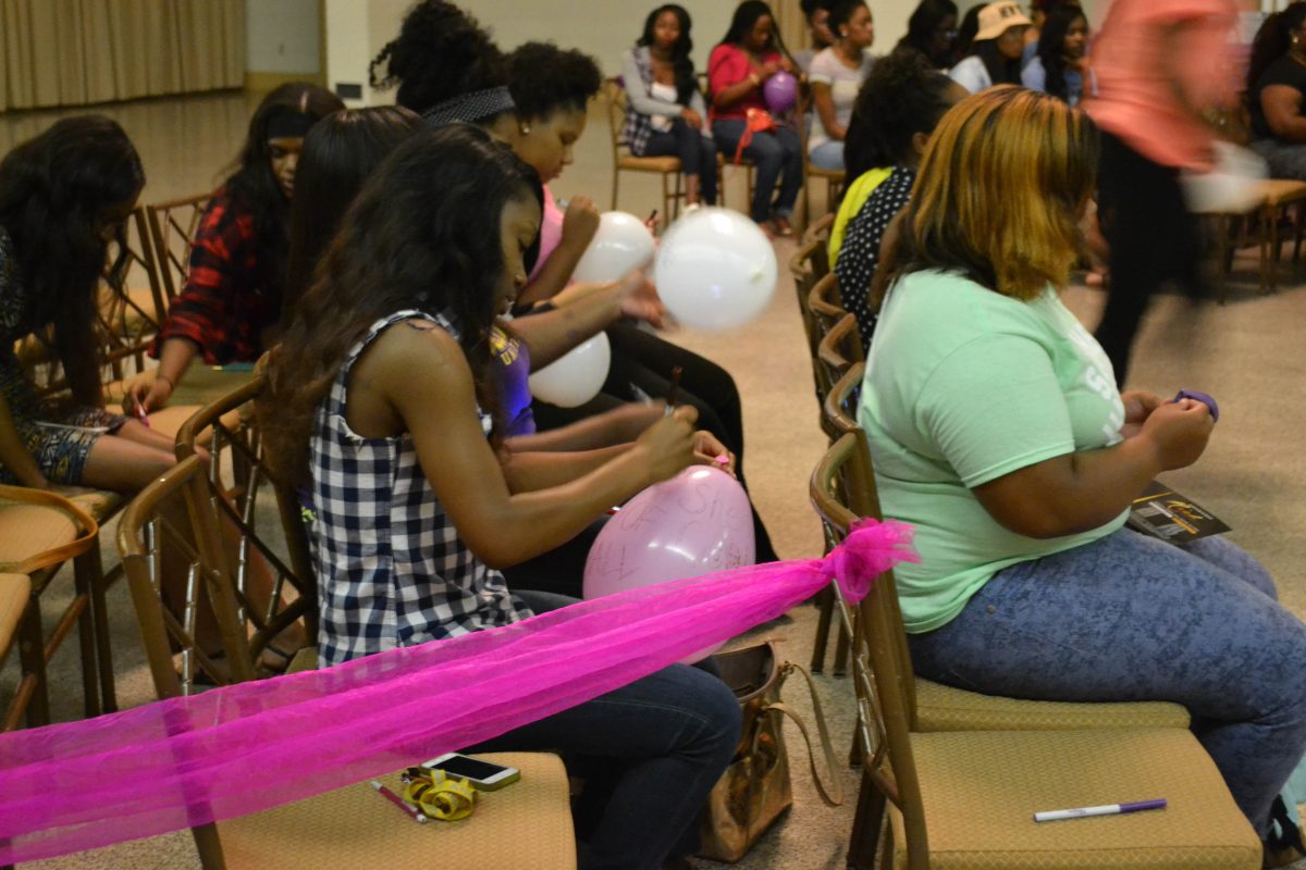 Female students sign balloons during the Association of Women Students Meet and Greet held in the Royal Cotillion Ballroom September 1,