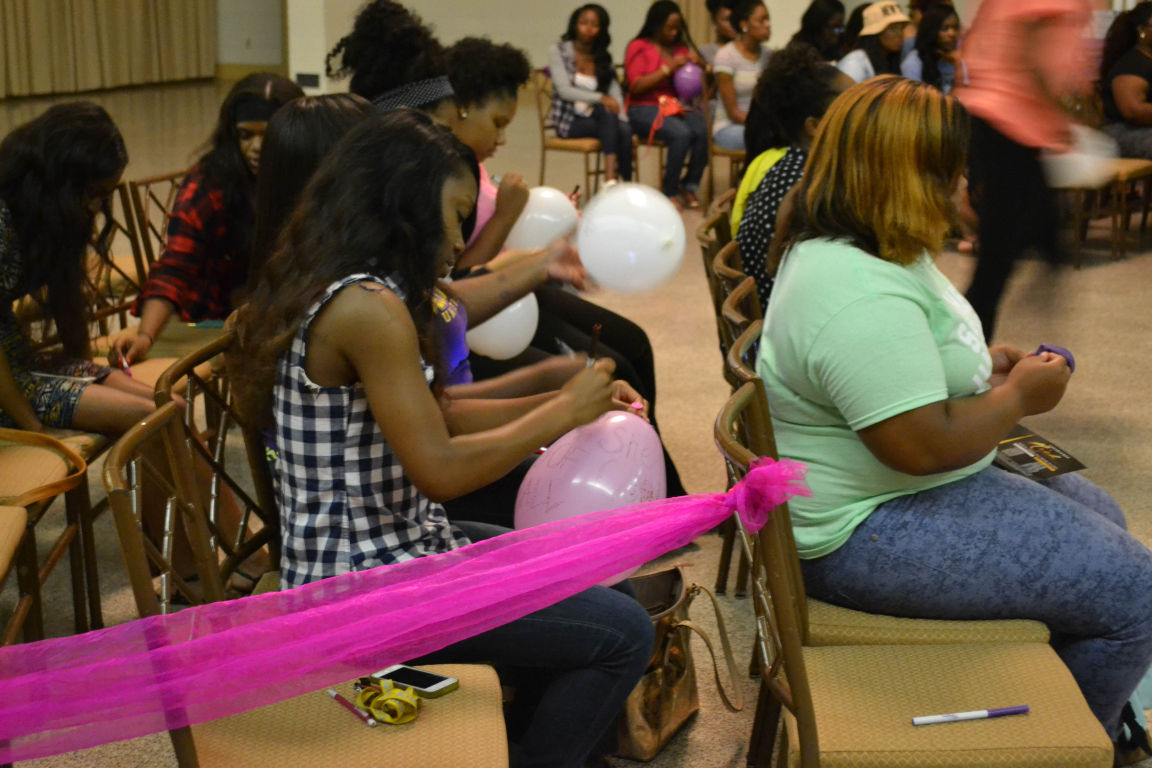 Female students sign balloons during the Association of Women Students Meet and Greet held in the Royal Cotillion Ballroom September 1,