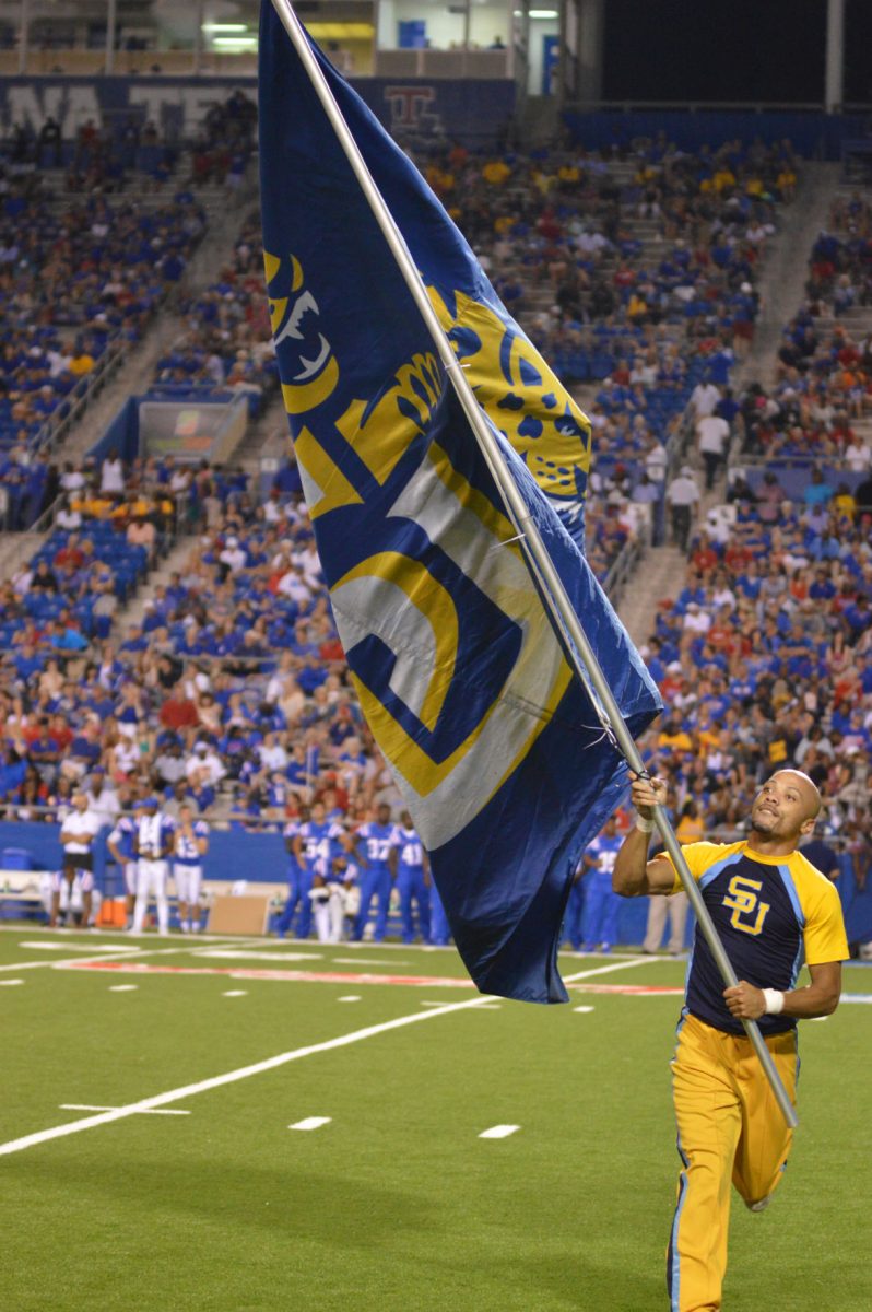 Southern University Senior cheerleader Melvin Richardson waves the Southern University flag proudly in celebration of a football touchdown versus Louisiana Tech in Ruston, Louisiana Sept 5.