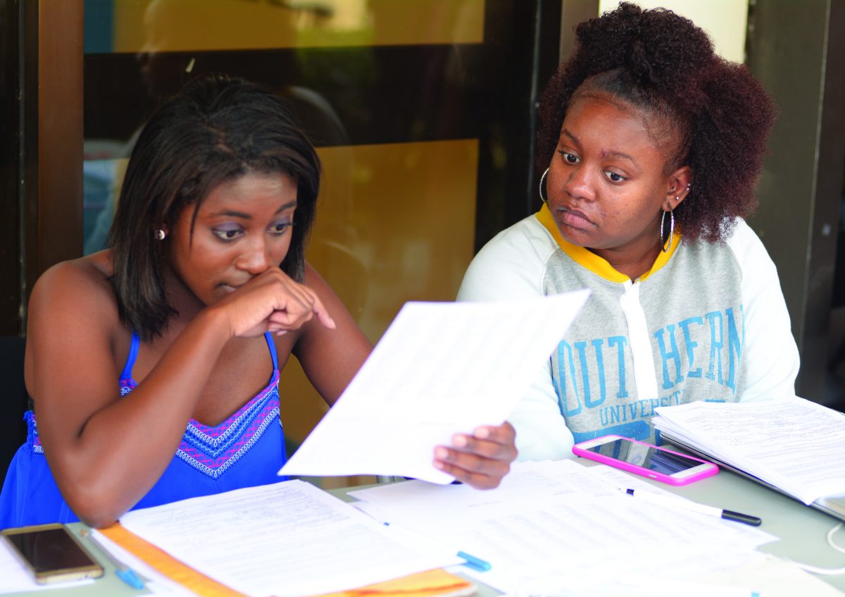 President of the Democratic Society of Southern University Angelle Bradford (left) and official memeber Kennedy Blache (right) review student applications for voter registration, Wednesday, September 23.