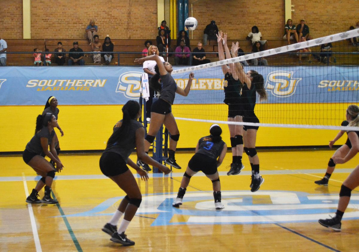 Senior middle blocker Leilani Lealaimatafao soars over the net and readies for a kill against two Tennessee state blockers.