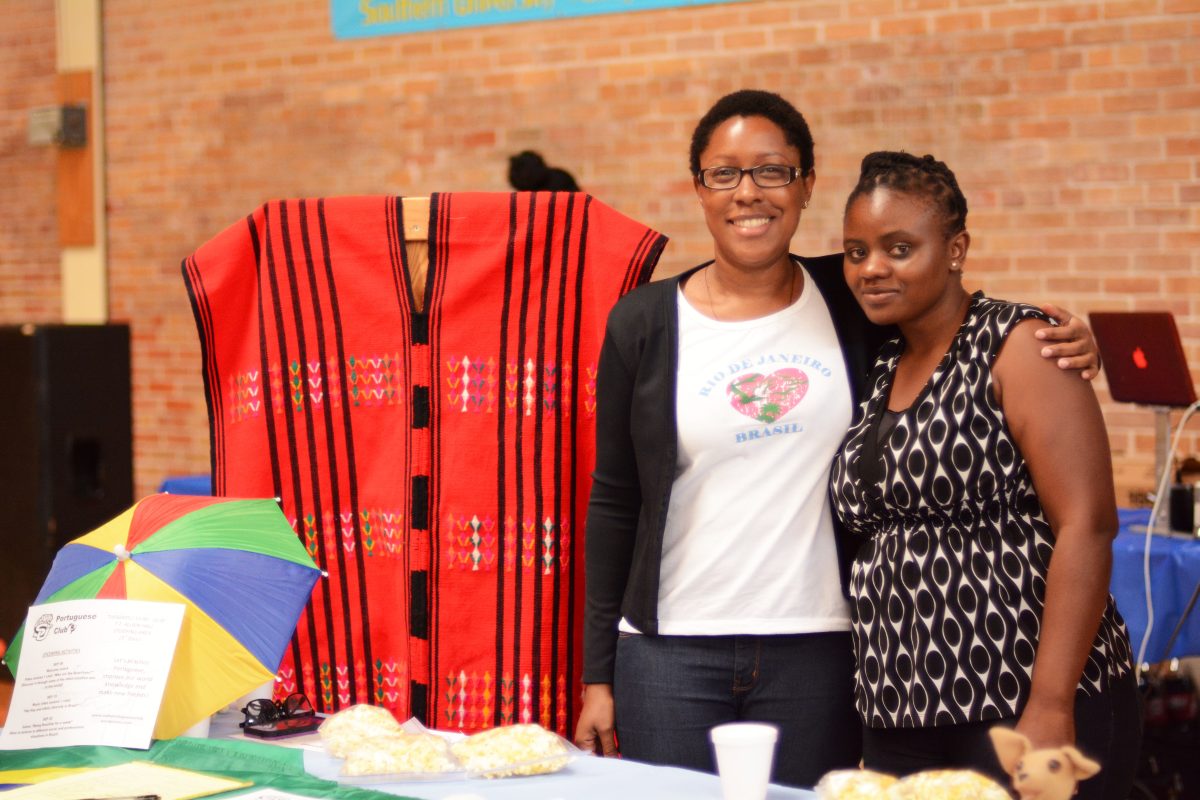 Foreign Language teaching assistant Ms. Fullbright (LEFT) and Southern University Graduate Student Sylvia Olwochi (RIGHT) pose next to a traditional Portuguese poncho and popcorn during the Organization Fair held in Seymour Gym.