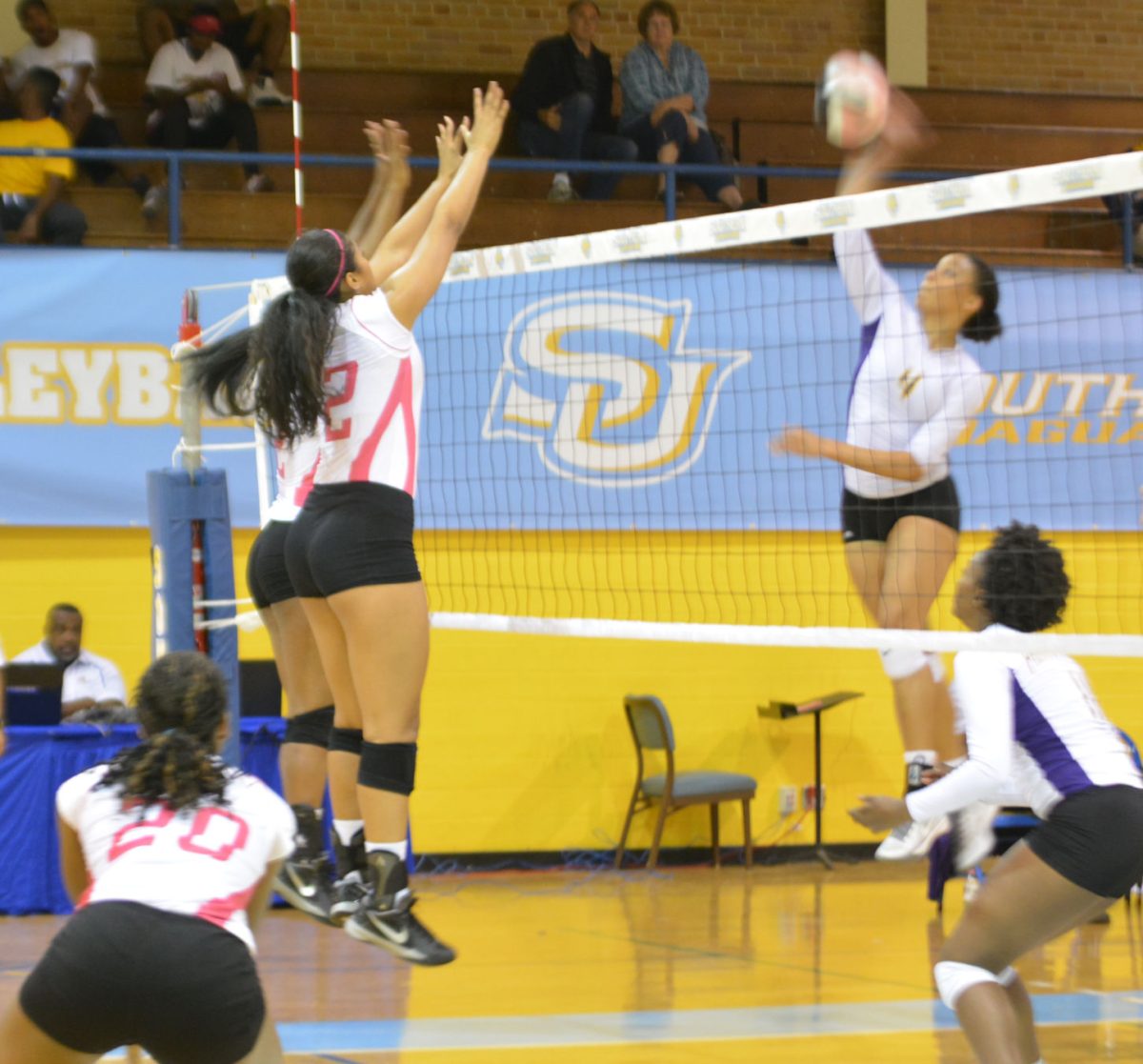 Senior Leilani Lealaimatafao and Junior Melodie Malone prepared them selves to reject an attempted kill against Freshman outside hitter Randi Hunter of the Prarie View Panthers .