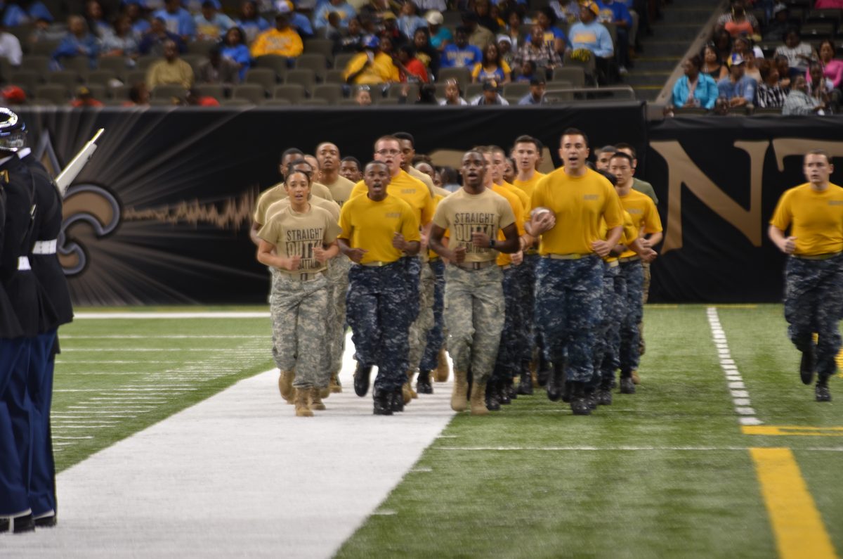 Members of Army and Navy ROTC from Southern, LSU, Southeastern, and Baton Rouge Community College jog in the Bayou Classic game ball on Saturday, November 28.