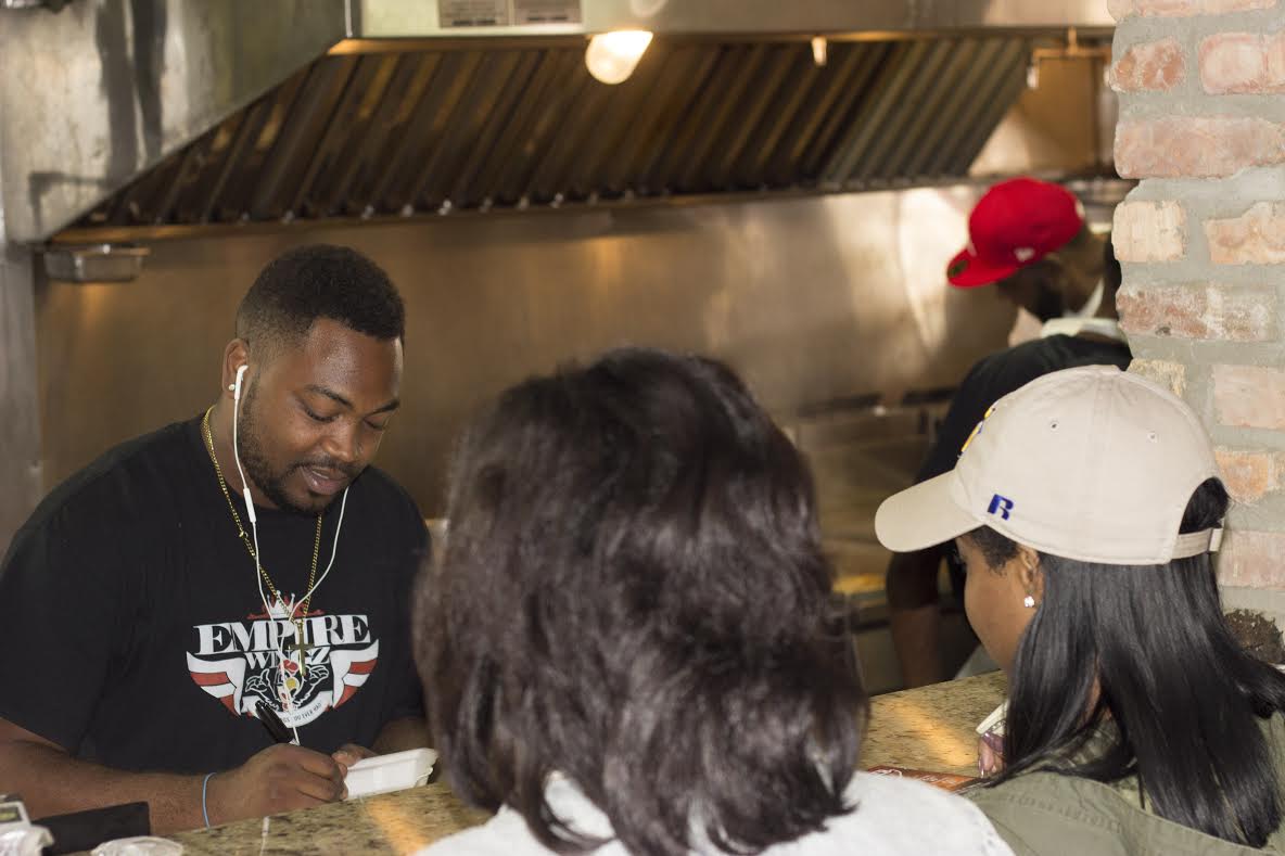 Co-Owner of Empire wings Victor Smith takes two customers orders. Empire Wings is the newest restaurant to open across The Hump specializing in serving wings.