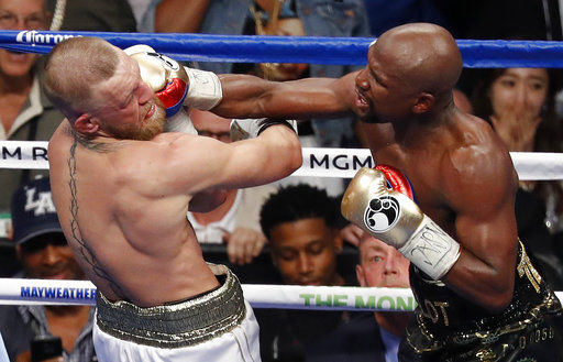 Floyd Mayweather Jr. hits Conor McGregor in a super welterweight boxing match Saturday, Aug. 26, 2017, in Las Vegas. (AP Photo/Eric Jamison)