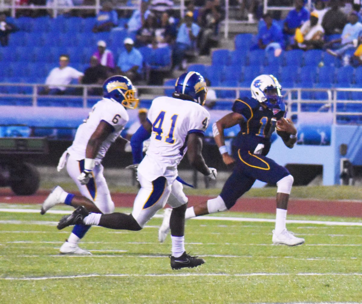 <p>Freshman quarterback, John Lampley, rushes past a pair of Fort Valley defenders on Saturday, September 30 at A.W. Mumford. (Arnita Dove/DIGEST)</p>