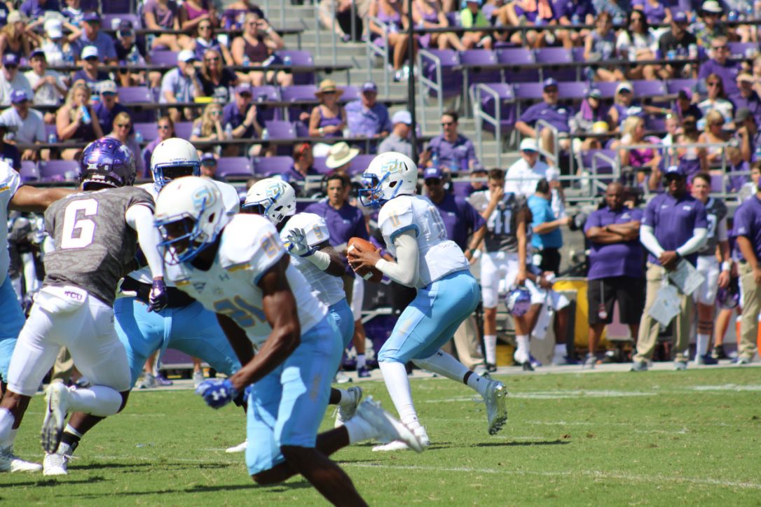 Sophomore Quarterback John Lampley shuffles in the pocket to avoid a group of TCU Defenders during the Jaguars matchup against Texas Christian University on Saturday, September 1st in Amon G. Carter Stadium in Fort Worth, TX.