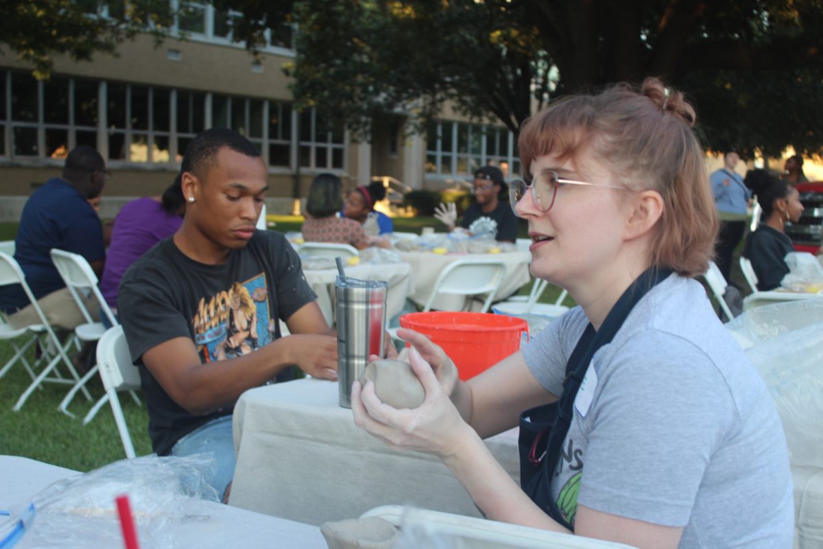 Instructor Arlie Opl showing students how to properly shape clay. Nodea Sewell