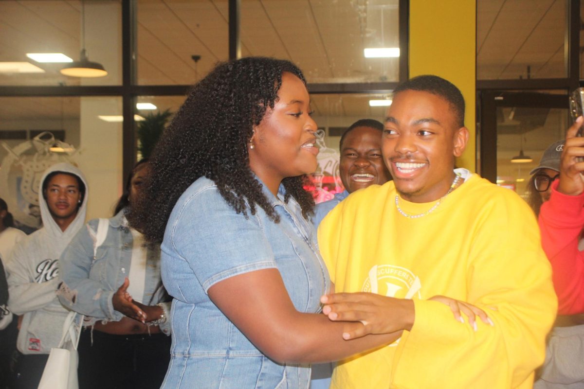 London Coleman celebrates with her cousin Bryman Williams Jr. after just being announced Miss Freshman. 
